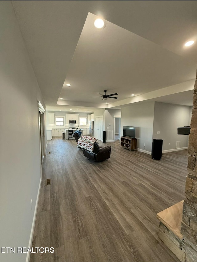 unfurnished living room with wood-type flooring and ceiling fan