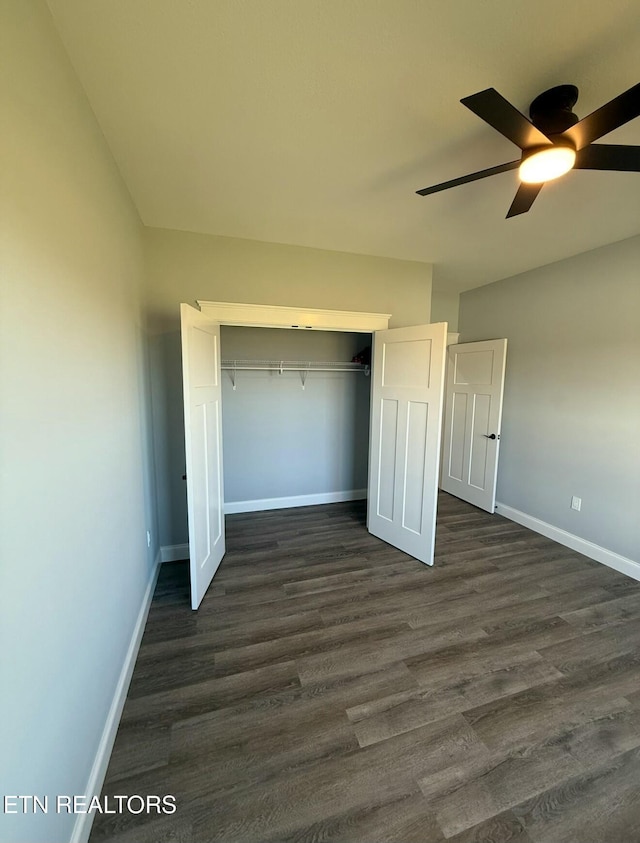 unfurnished bedroom with ceiling fan, dark hardwood / wood-style flooring, and a closet