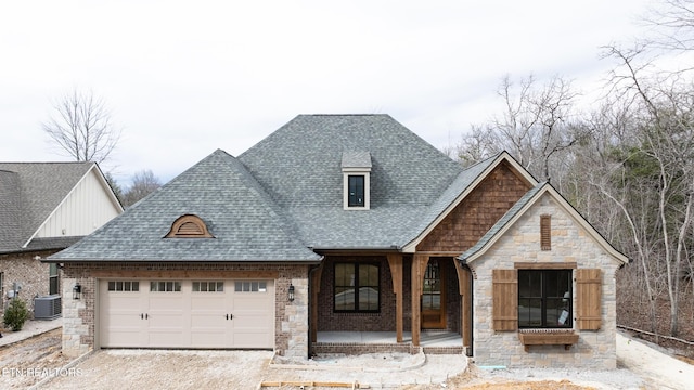 view of front facade featuring a garage, central AC unit, and covered porch