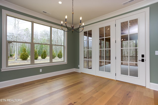 unfurnished dining area with an inviting chandelier and light wood-type flooring