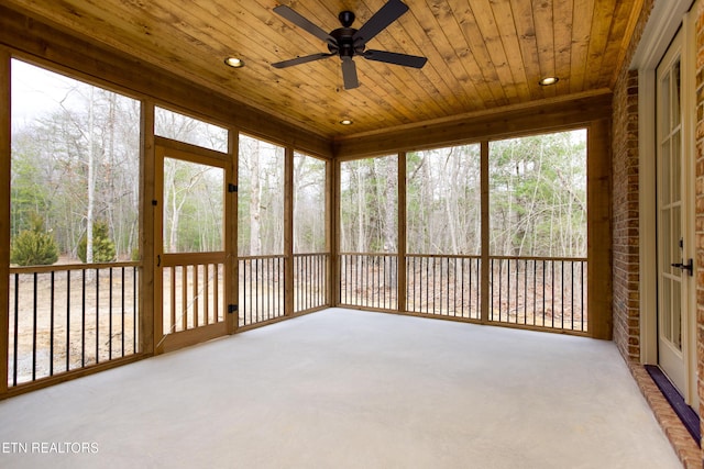 unfurnished sunroom featuring wood ceiling and ceiling fan