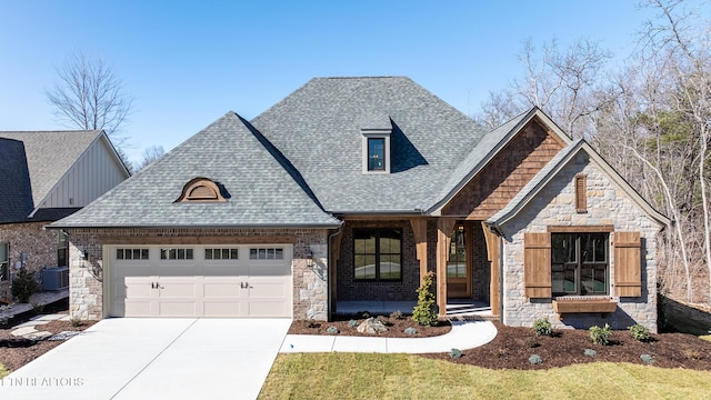 view of front facade with roof with shingles, concrete driveway, central AC unit, a garage, and stone siding