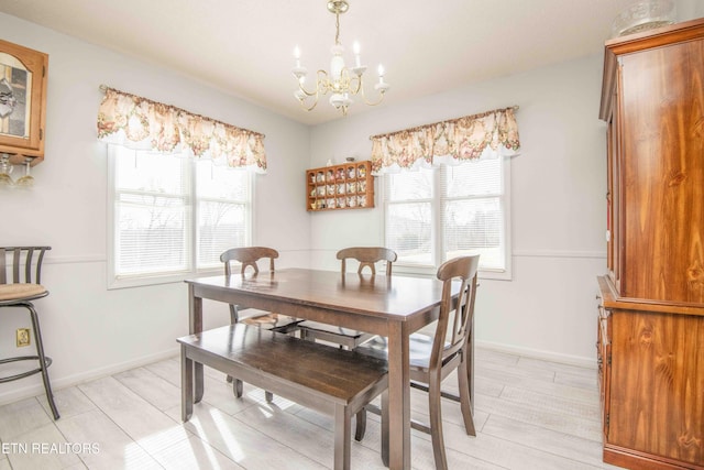 dining room featuring a healthy amount of sunlight, light hardwood / wood-style floors, and a notable chandelier