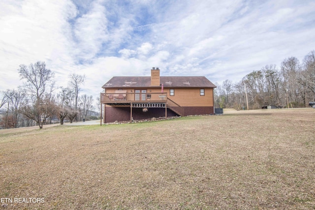 back of property with a wooden deck and a lawn