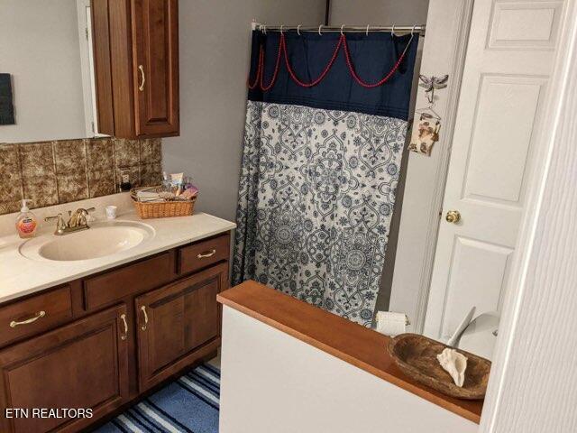 bathroom featuring vanity and backsplash