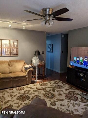 living room featuring ceiling fan, dark hardwood / wood-style floors, and a textured ceiling