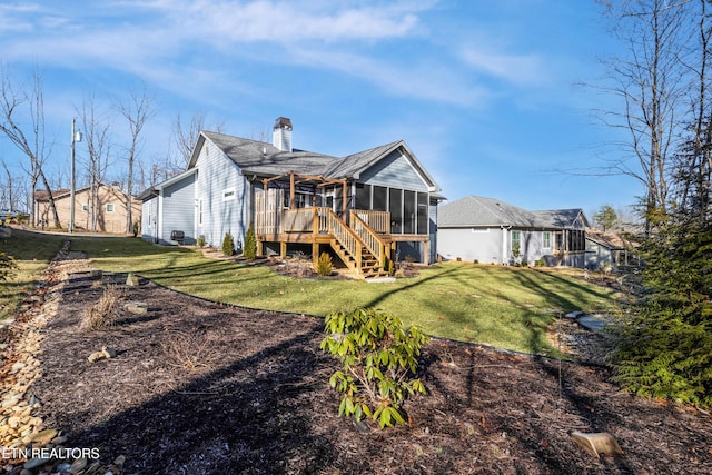 rear view of property featuring a sunroom and a lawn