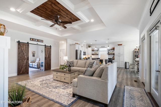 living room featuring ornamental molding, a barn door, dark wood-type flooring, and ceiling fan