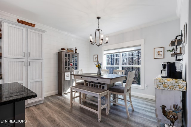 dining space featuring dark hardwood / wood-style flooring, ornamental molding, and an inviting chandelier