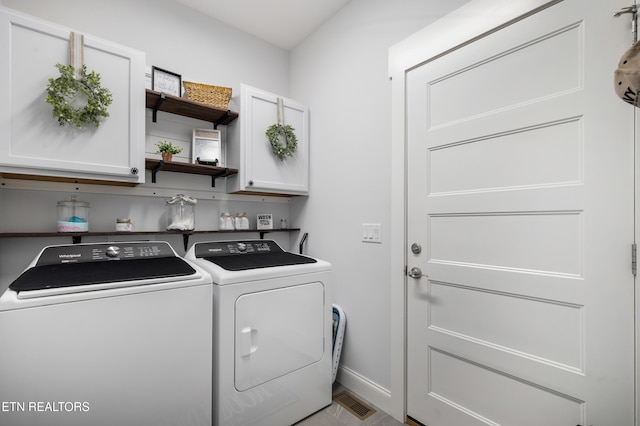 laundry area featuring cabinets and washer and clothes dryer