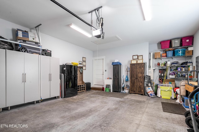 garage featuring black fridge and a garage door opener