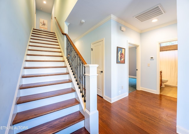 staircase featuring visible vents, crown molding, baseboards, recessed lighting, and wood finished floors