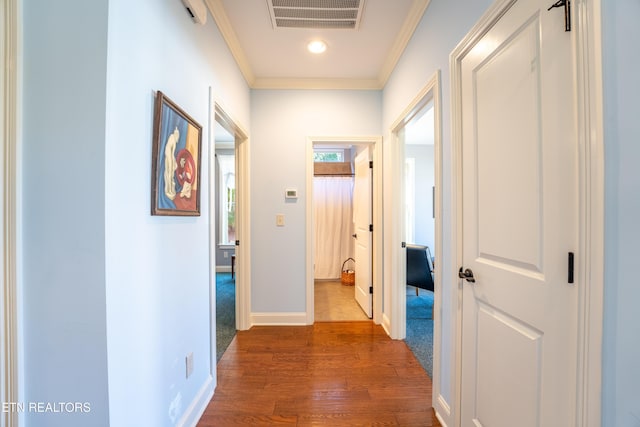 corridor with visible vents, baseboards, ornamental molding, and dark wood finished floors