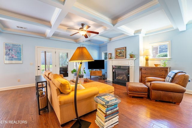 living room featuring visible vents, wood-type flooring, baseboards, and beamed ceiling