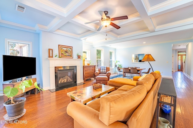 living room featuring visible vents, beam ceiling, light wood-style flooring, and a ceiling fan