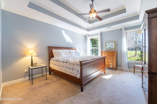 carpeted bedroom featuring visible vents, crown molding, a raised ceiling, and baseboards