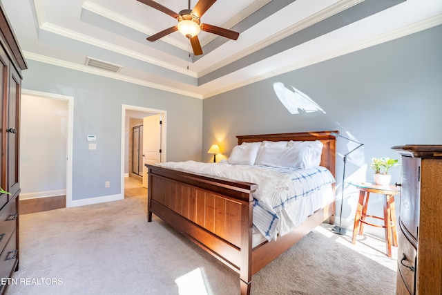 bedroom with visible vents, a raised ceiling, light carpet, and crown molding