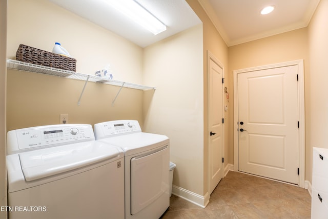 laundry room with light tile patterned floors, baseboards, washing machine and clothes dryer, laundry area, and crown molding