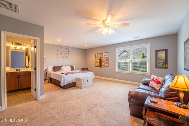 bedroom with baseboards, visible vents, ensuite bathroom, and light carpet