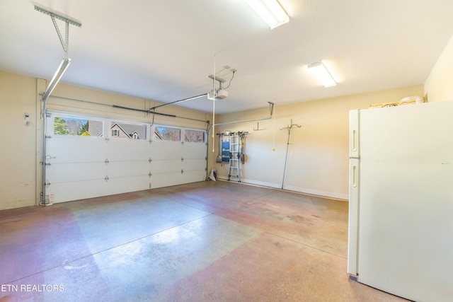 garage featuring a garage door opener and freestanding refrigerator