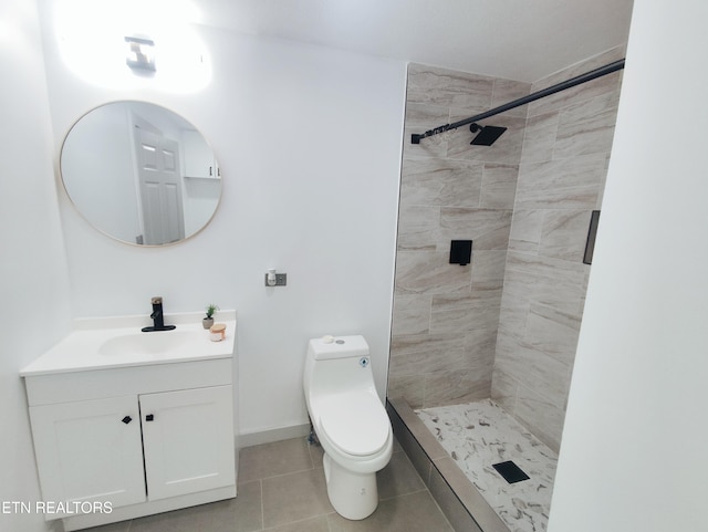 bathroom featuring vanity, tiled shower, tile patterned floors, and toilet