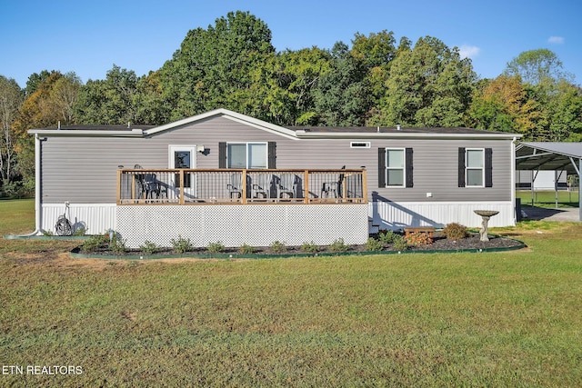 rear view of property with a carport, a wooden deck, and a yard