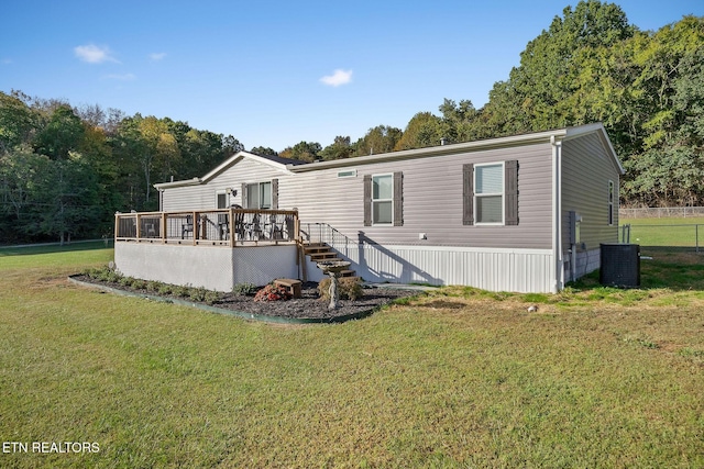 back of house with a wooden deck, a yard, and cooling unit