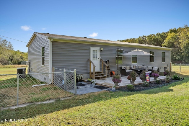 back of house with central AC unit and a lawn