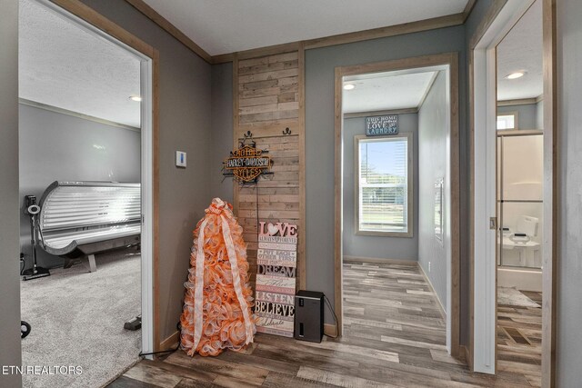 bathroom with hardwood / wood-style flooring, ornamental molding, and a textured ceiling