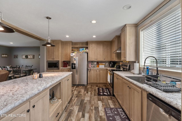 kitchen with stainless steel appliances, light stone countertops, pendant lighting, and light brown cabinets