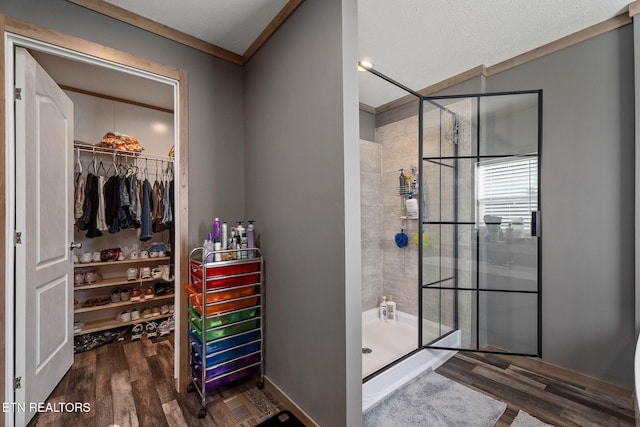 bathroom with hardwood / wood-style flooring, ornamental molding, and tiled shower