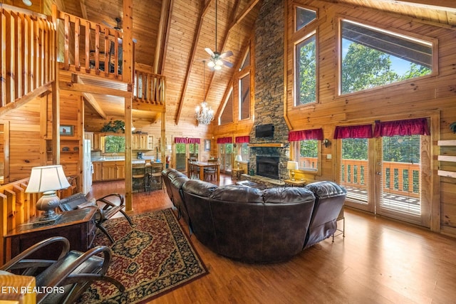 living room with wooden ceiling, wood walls, beamed ceiling, and wood finished floors