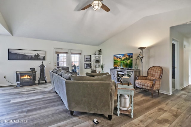 living room with hardwood / wood-style floors, vaulted ceiling, a fireplace, and ceiling fan