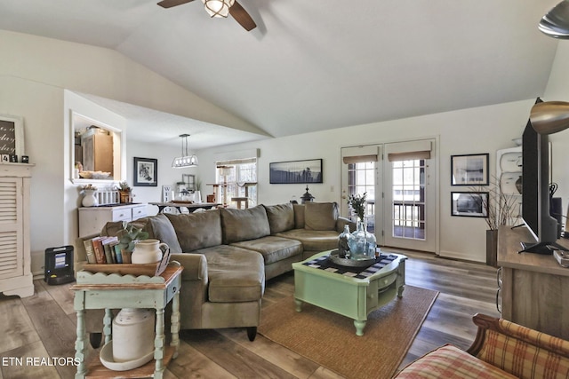 living room with dark hardwood / wood-style flooring, vaulted ceiling, ceiling fan, and plenty of natural light