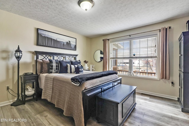 bedroom with hardwood / wood-style floors and a textured ceiling