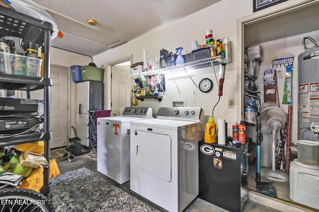 laundry room featuring washing machine and clothes dryer, water heater, and a textured ceiling