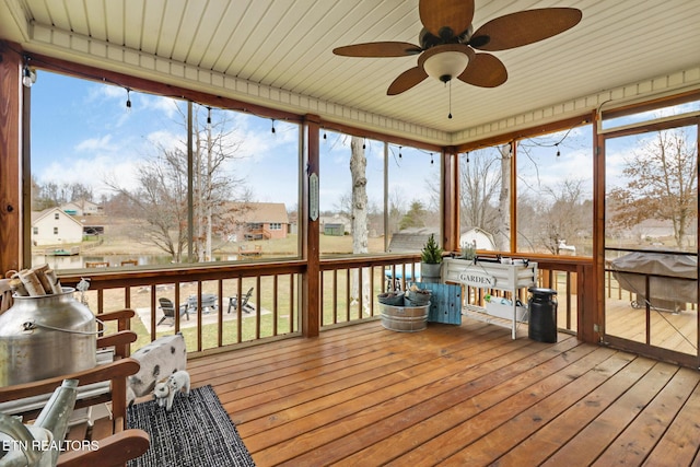 unfurnished sunroom with ceiling fan