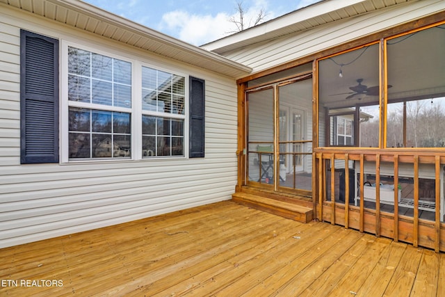 wooden deck featuring ceiling fan and a sunroom