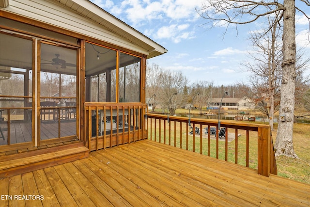 deck featuring a yard and a sunroom