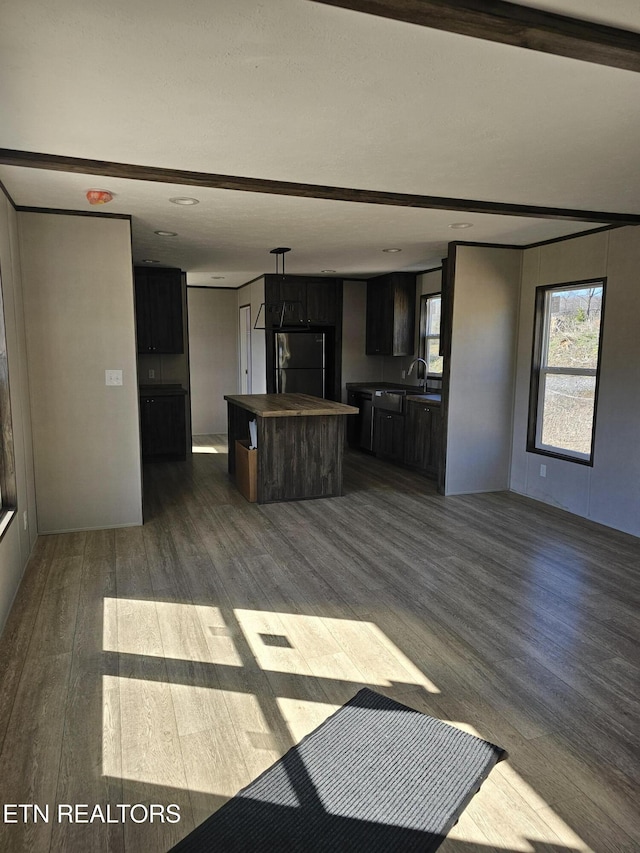 kitchen featuring a kitchen island, fridge, dark wood-type flooring, and sink