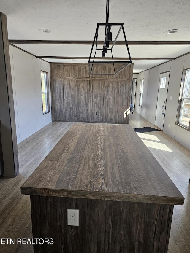 interior space with hardwood / wood-style floors, beam ceiling, and a textured ceiling