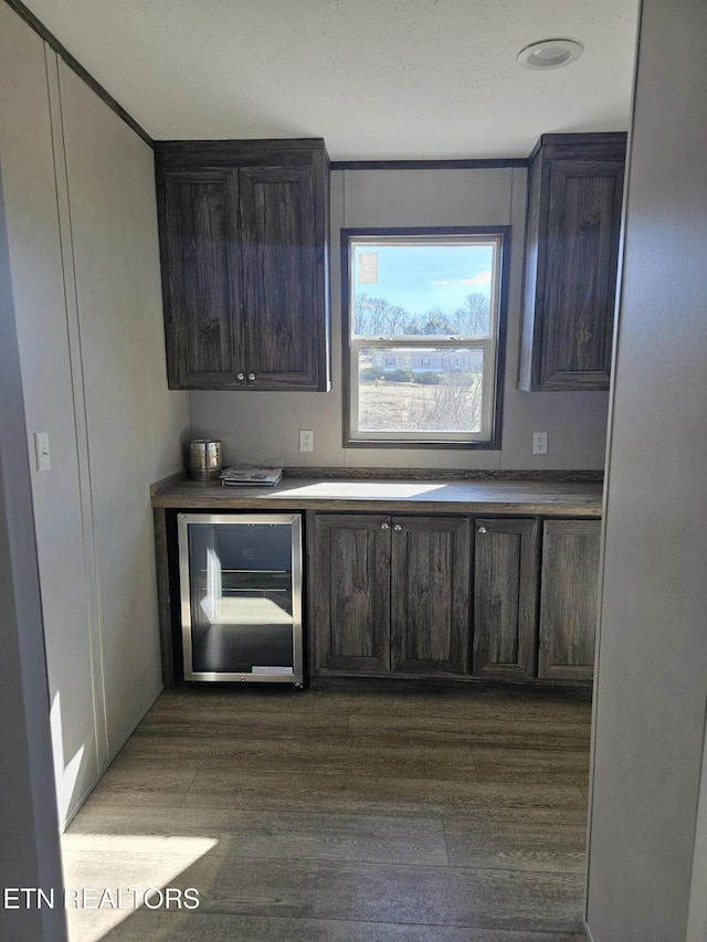 bar with dark brown cabinets, dark hardwood / wood-style floors, and wine cooler