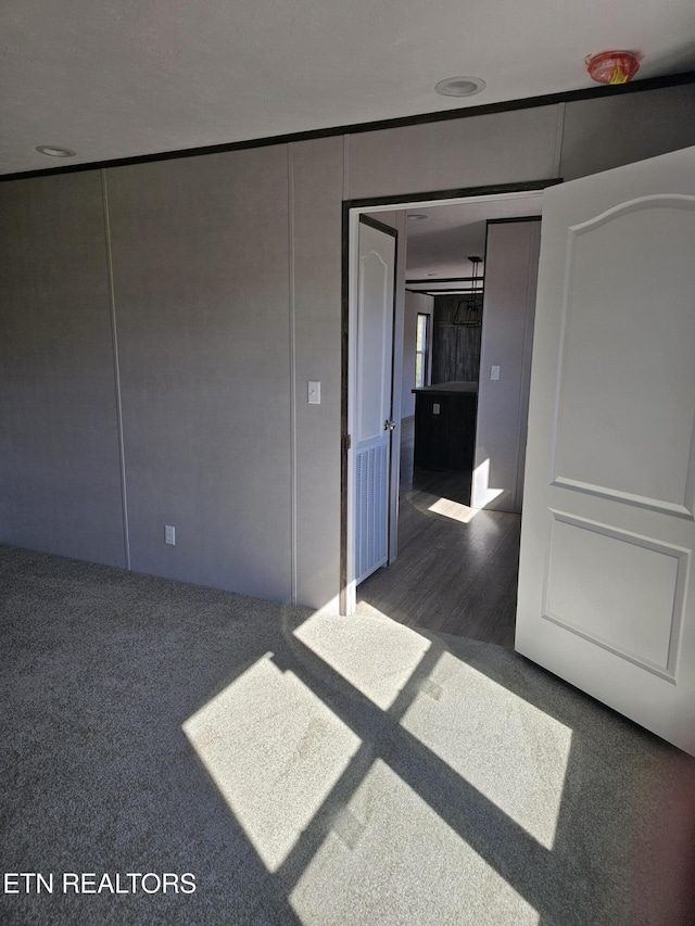 unfurnished room featuring dark colored carpet