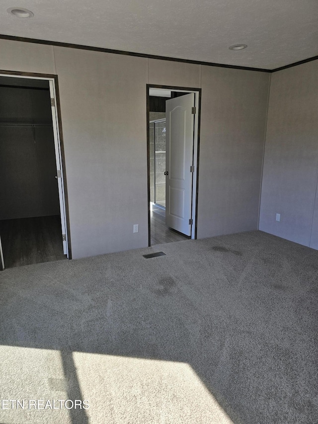 spare room featuring ornamental molding, carpet floors, and a textured ceiling