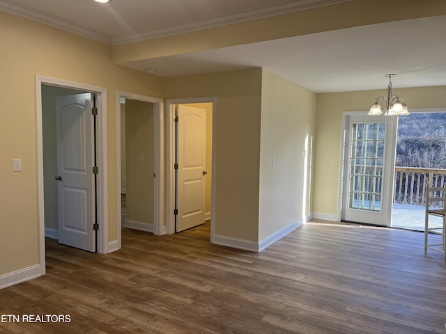 unfurnished room featuring wood-type flooring, ornamental molding, and a chandelier