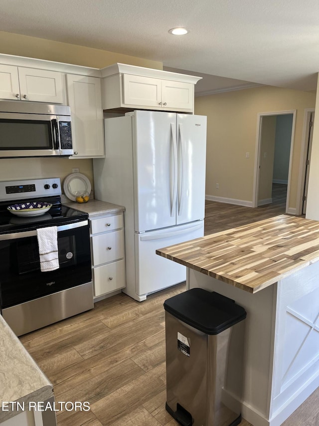 kitchen with white cabinetry, appliances with stainless steel finishes, and light wood-type flooring