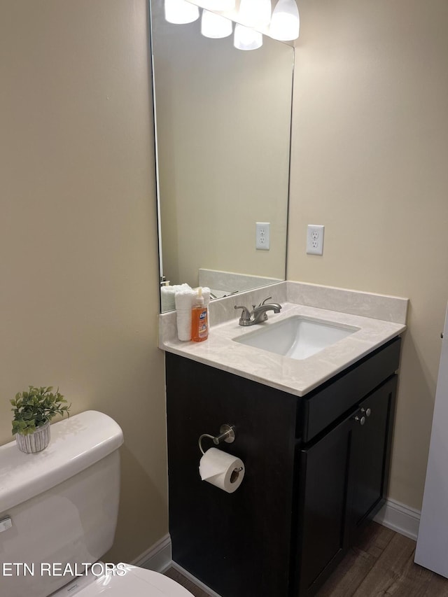 bathroom featuring vanity, wood-type flooring, and toilet