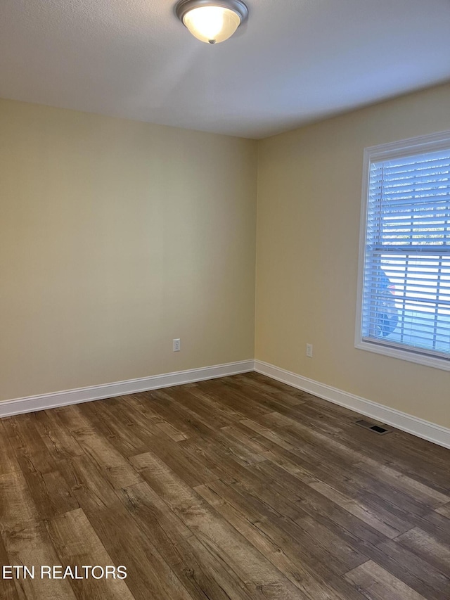 spare room featuring dark wood-type flooring