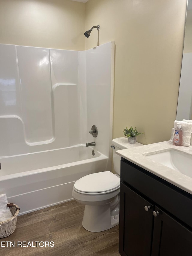 full bathroom with hardwood / wood-style flooring, vanity, toilet, and shower / bathing tub combination