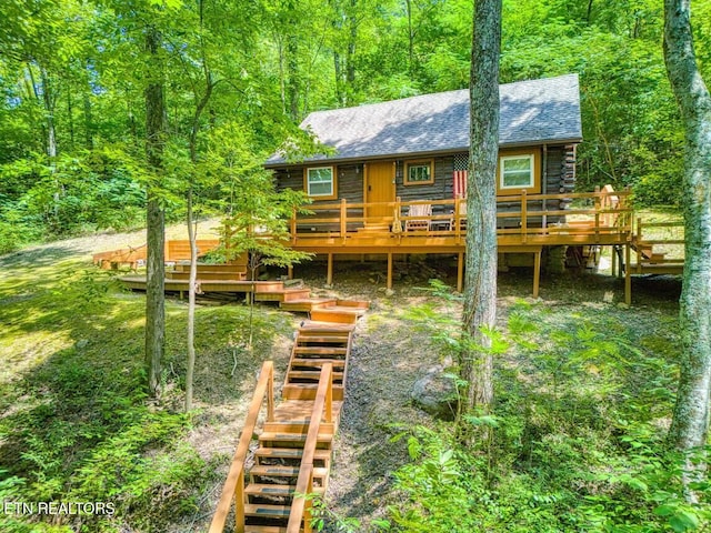 rear view of property featuring a wooden deck